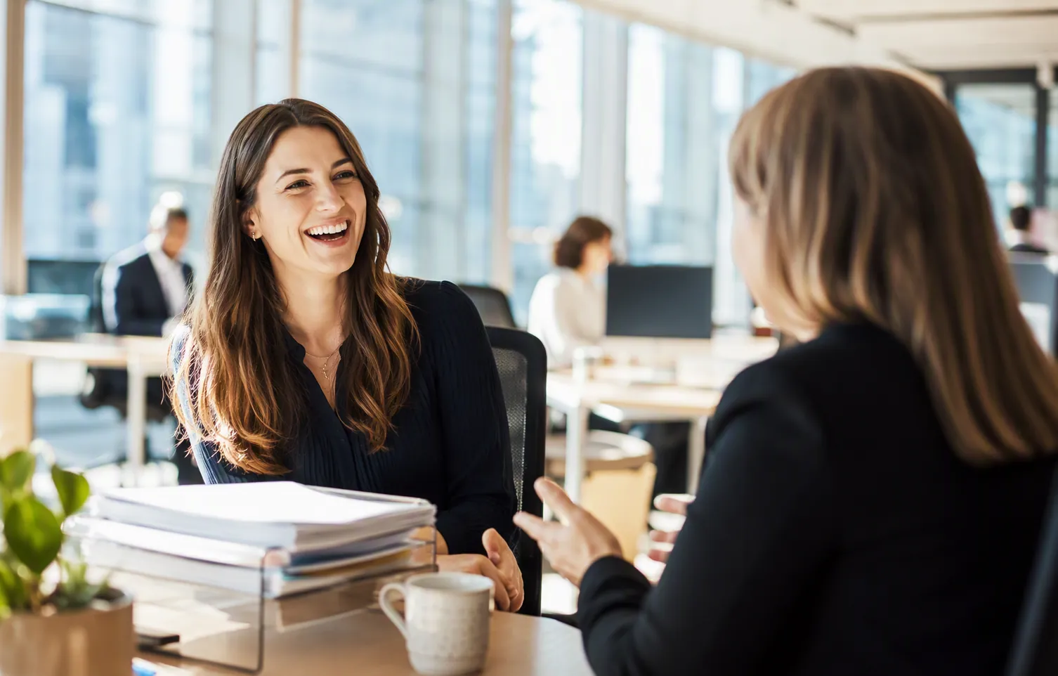 A Denali loan officer in conversation with a client at the office